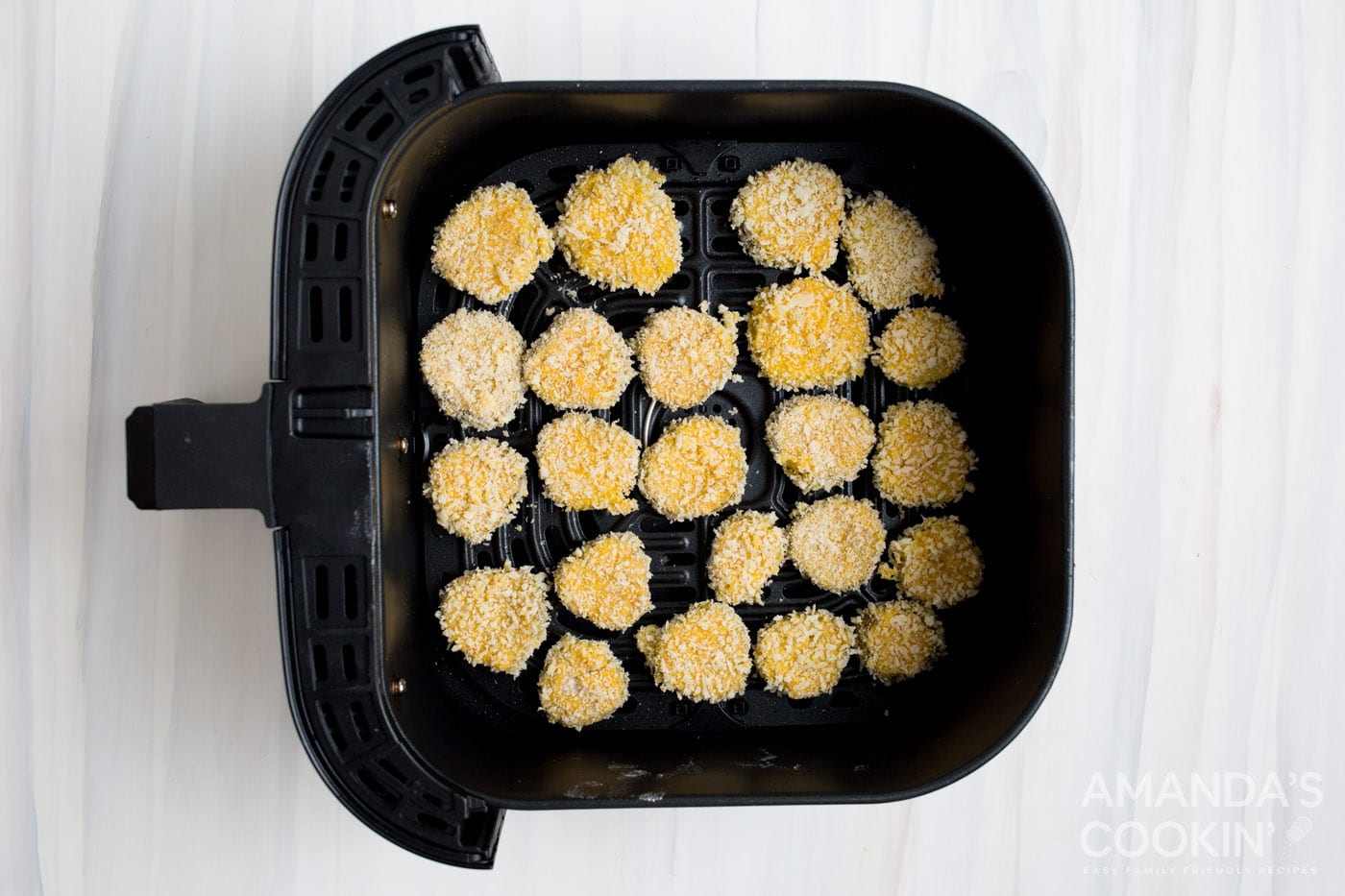 panko coated pickle chips in an air fryer basket
