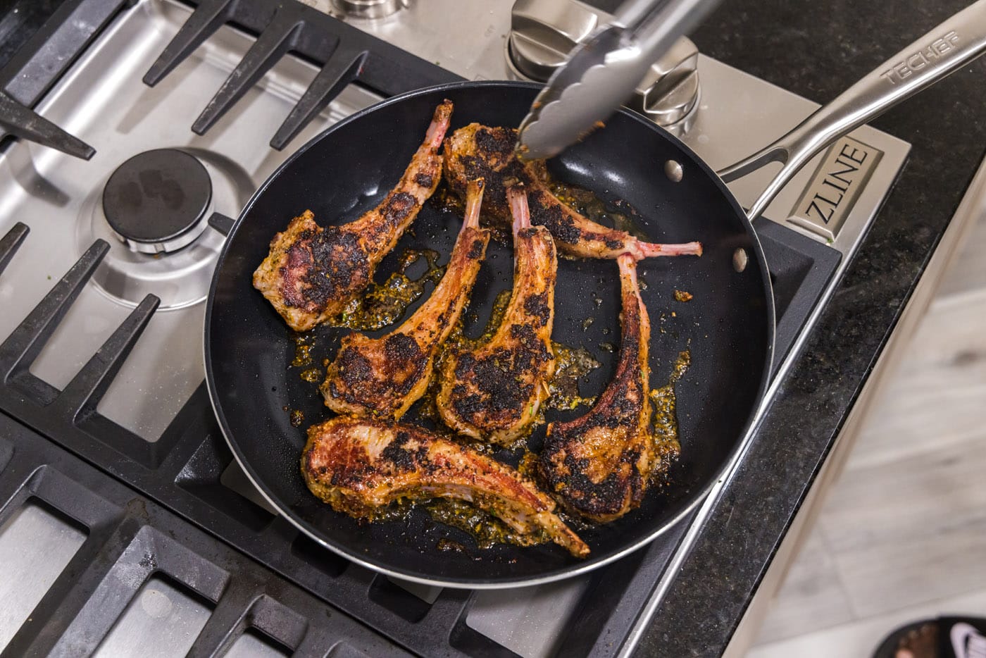 flipping lamb chops in a skillet