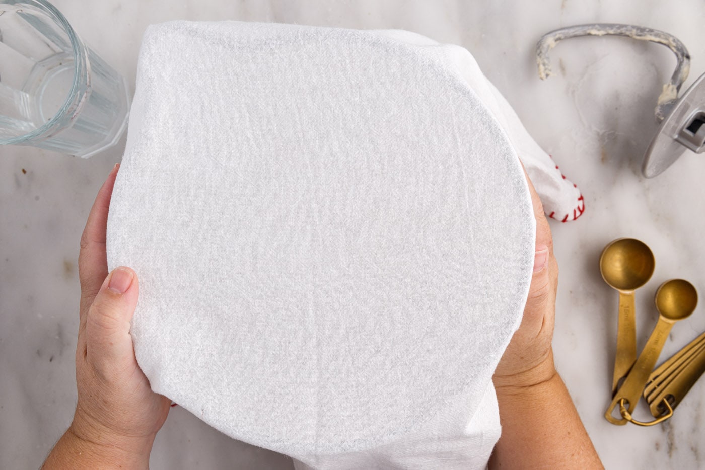 covering bread dough with a kitchen towel