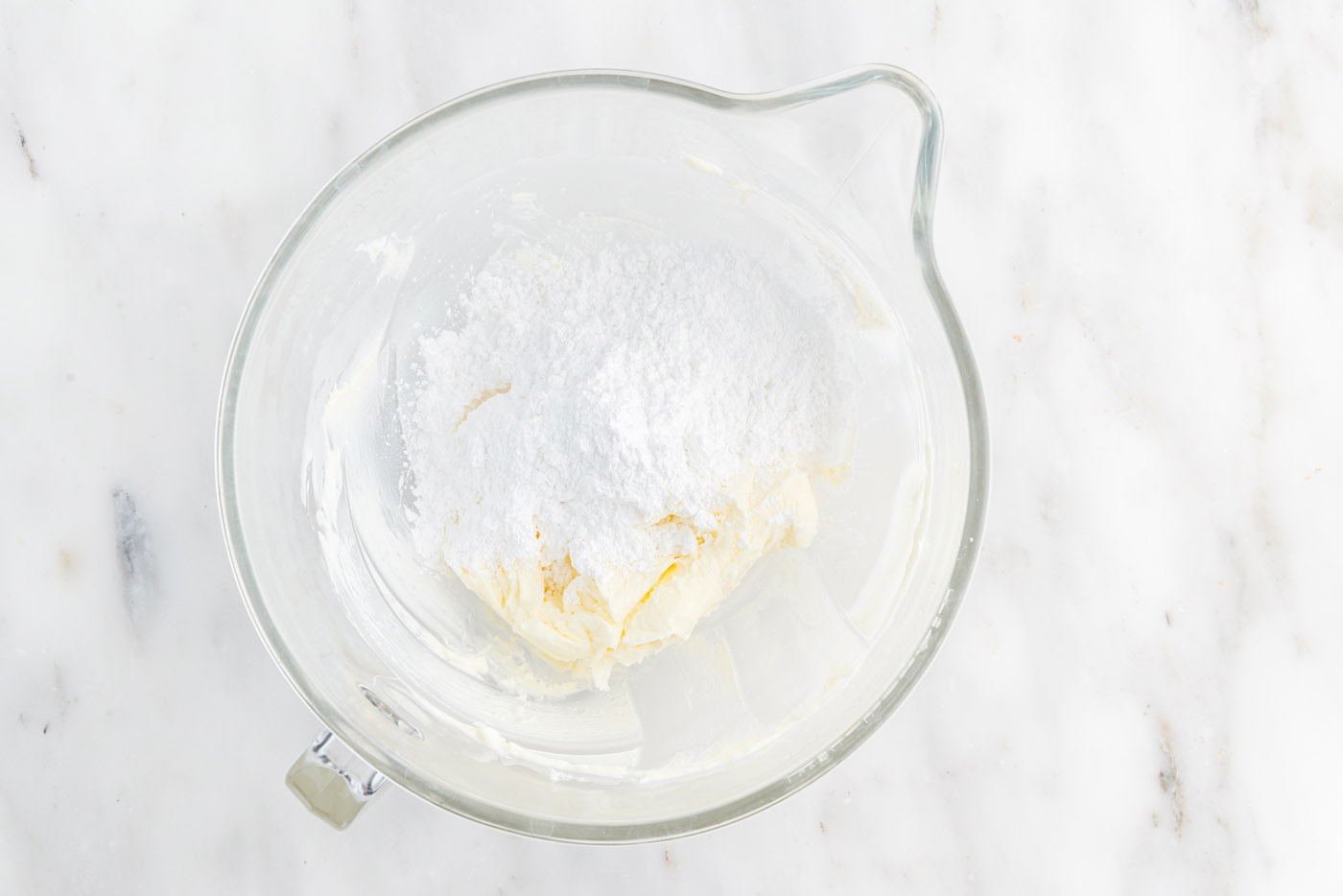 powdered sugar added to butter in a stand mixer bowl