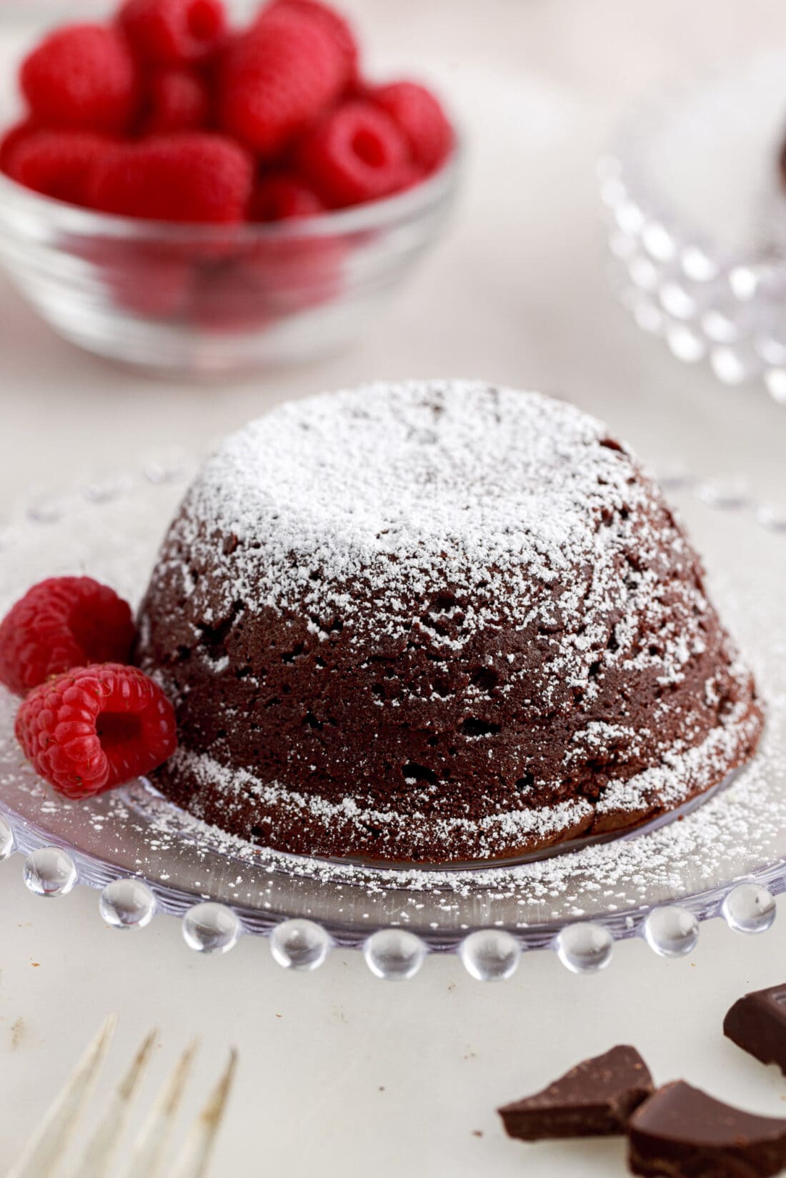 Lava Cake on a plate with raspberries topped with powdered sugar