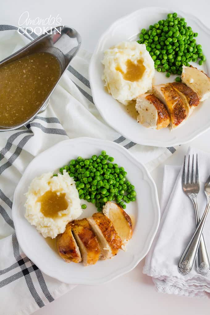 Crockpot Chicken on a plate with peas, potatoes, and gravy